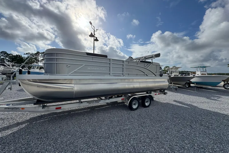 Slide: The Image of 2026 Bennington 22 SSR pontoon boat on trailer under cloudy sky. - 9