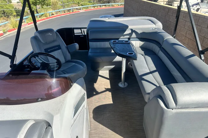 Slide: The Image of 2022 Bennington LX 24 L-Bench interior with gray seating and table. - 13