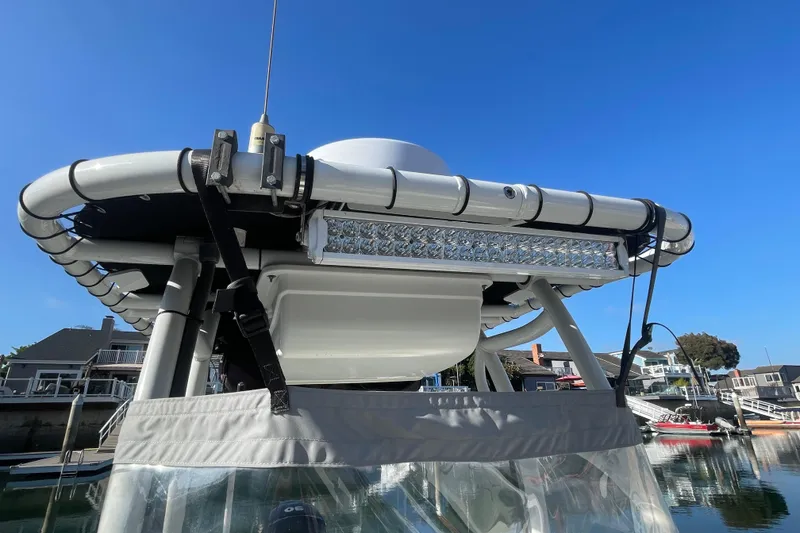 Slide: The Image of 2006 Boston Whaler 170 Montauk with mounted light bar, docked under clear blue sky. - 18