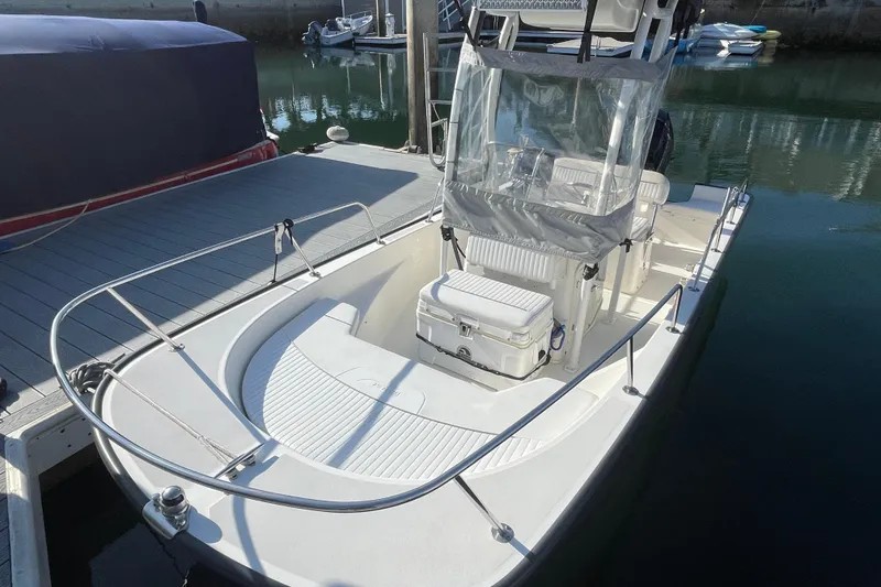 Slide: The Image of 2006 Boston Whaler 170 Montauk boat docked, featuring a center console and spacious deck. - 3