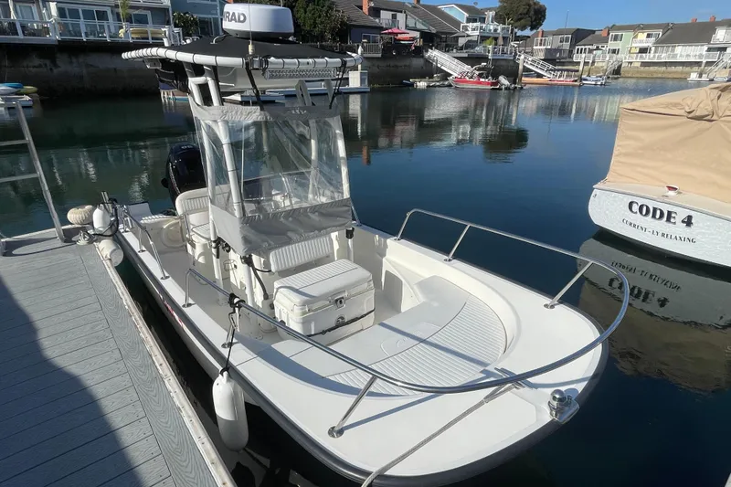 Slide: The Image of 2006 Boston Whaler 170 Montauk docked in a serene marina setting. - 6