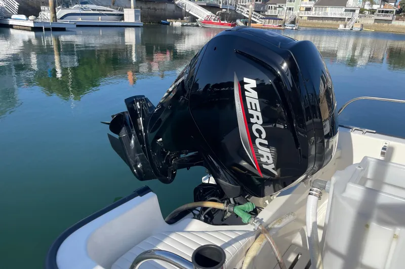 Slide: The Image of Outboard motor on a 2006 Boston Whaler 170 Montauk in a marina setting. - 7