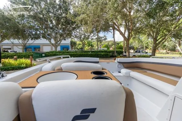 Slide: The Image of 2021 Starcraft SVX 191 OB boat interior with seating and cup holders, surrounded by trees. - 11