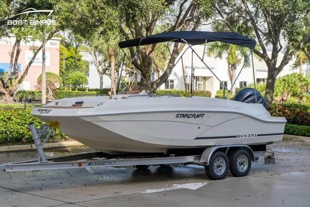 Slide: The Image of 2021 Starcraft SVX 191 OB boat on trailer with canopy, parked outdoors. - 0