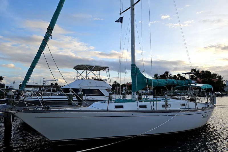 The Image of Sailboat docked at sunset, Tartan 37 model, 1987, with teal covers. - 0