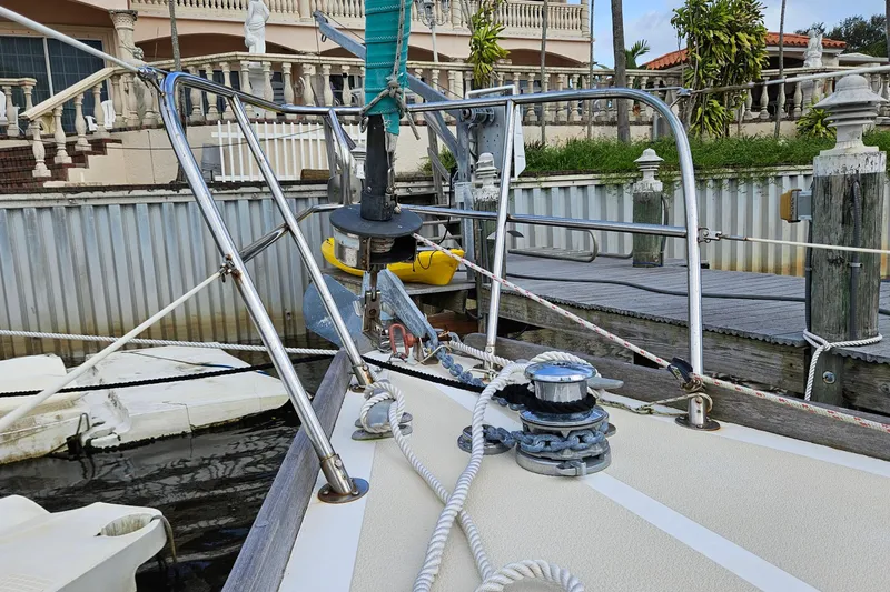 Slide: The Image of Bow of 1987 Tartan 37 sailboat docked, featuring winch and anchor equipment. - 12