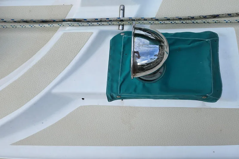 Slide: The Image of Close-up of a 1987 Tartan 37 sailboat deck with a metal fixture and teal cover. - 19