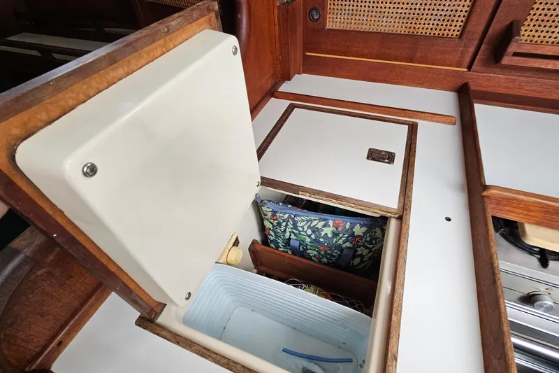 Slide: The Image of Interior storage compartment on a 1987 Tartan 37 sailboat, featuring wooden cabinetry. - 32