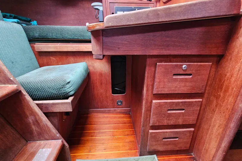 Slide: The Image of Interior of 1987 Tartan 37 sailboat with wooden cabinetry and green seating. - 35