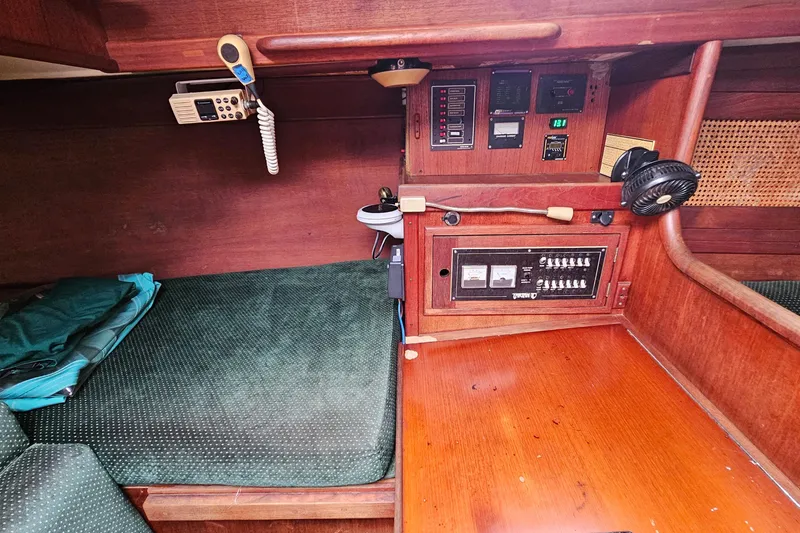 Slide: The Image of 1987 Tartan 37 yacht interior with control panel and green cushioned seating. - 36