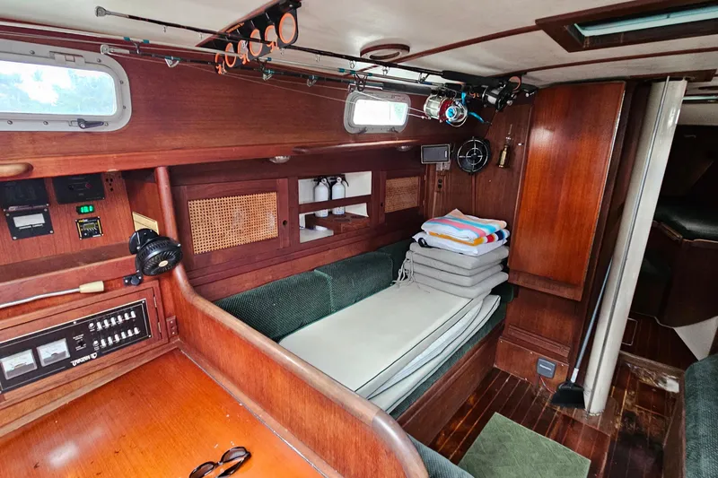 Slide: The Image of Cozy interior of a 1987 Tartan 37 sailboat with wooden furnishings and fishing rods. - 43