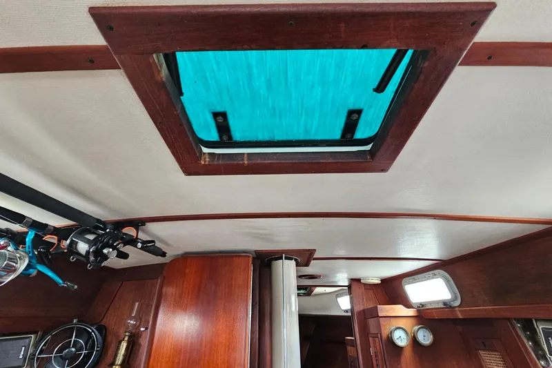 Slide: The Image of Interior view of a 1987 Tartan 37 sailboat, featuring a wooden cabin and ceiling hatch. - 46