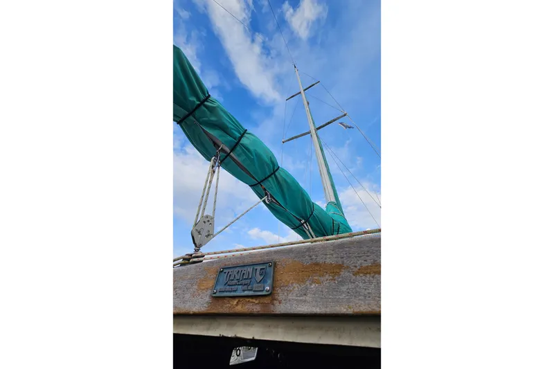Slide: The Image of 1987 Tartan 37 sailboat with green sail cover against blue sky. - 6