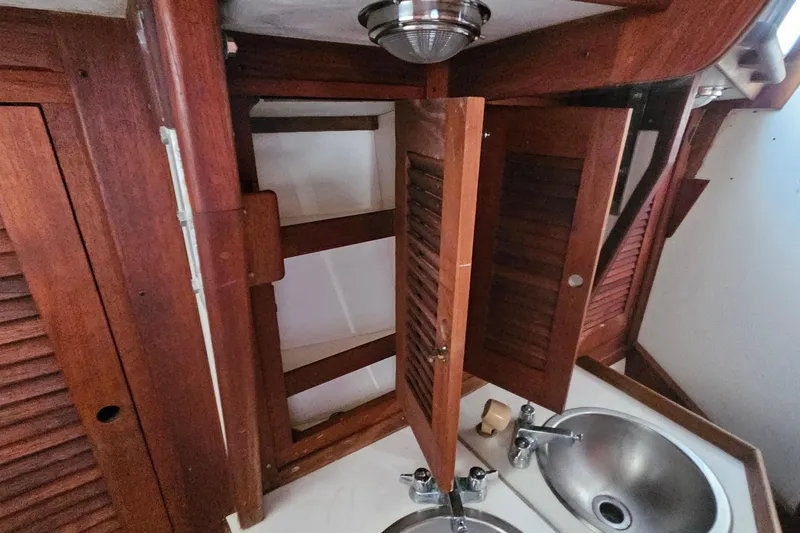 Slide: The Image of Interior of 1987 Tartan 37 sailboat with wooden cabinets and dual stainless steel sinks. - 60