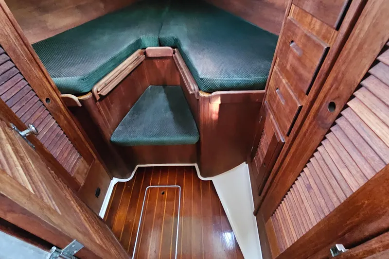 Slide: The Image of 1987 Tartan 37 sailboat interior with wooden cabinetry and green cushioned seating. - 62