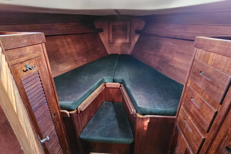 Slide: The Image of Cozy wooden cabin interior of 1987 Tartan 37 sailboat with cushioned seating. - 64