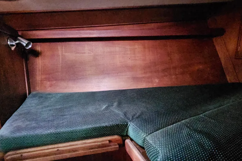 Slide: The Image of 1987 Tartan 37 yacht interior with wooden paneling and cushioned seating area. - 65