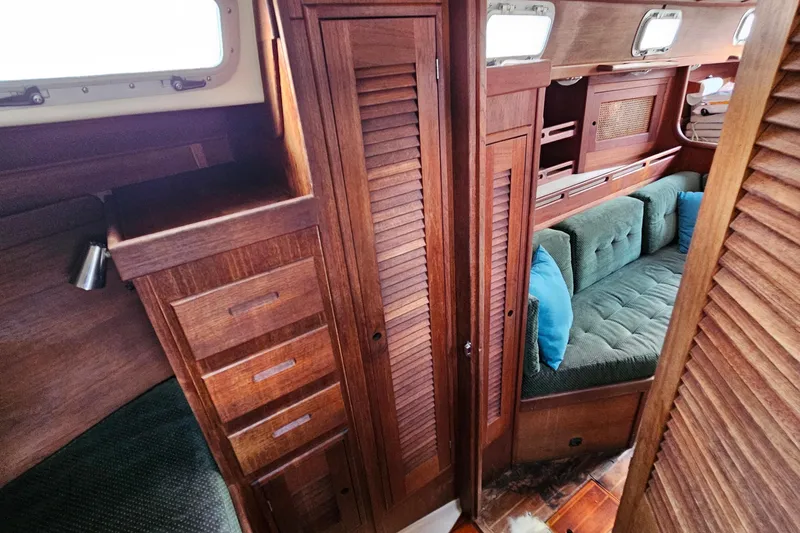 Slide: The Image of Interior of 1987 Tartan 37 sailboat with wooden cabinetry and green cushioned seating. - 69