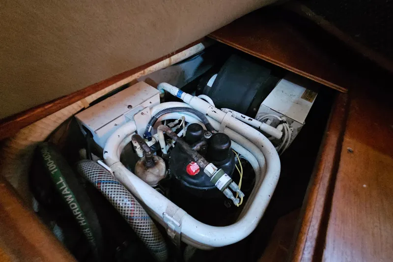 Slide: The Image of Engine compartment of a 1987 Tartan 37 sailboat, featuring hoses and mechanical components. - 73