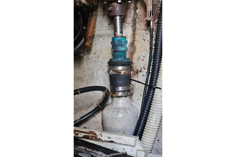 Slide: The Image of Engine compartment of a 1987 Tartan 37 sailboat, showing mechanical components and hoses. - 76