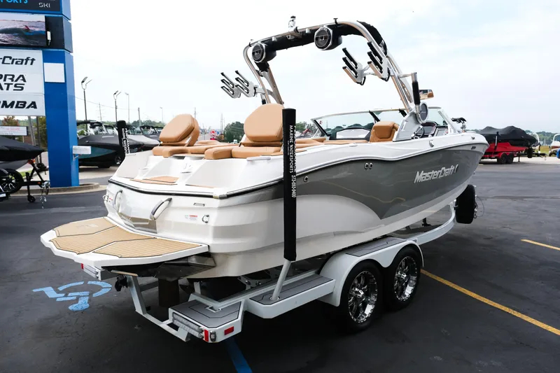 Slide: The Image of 2019 MasterCraft X22 boat on trailer, displayed at dealership, featuring sleek design and tan seating. - 12