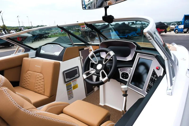 Slide: The Image of 2019 MasterCraft X22 boat interior with tan seating and modern dashboard controls. - 13