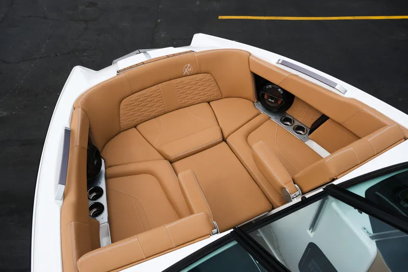 Slide: The Image of 2019 MasterCraft X22 boat interior with tan leather seating and cup holders. - 19