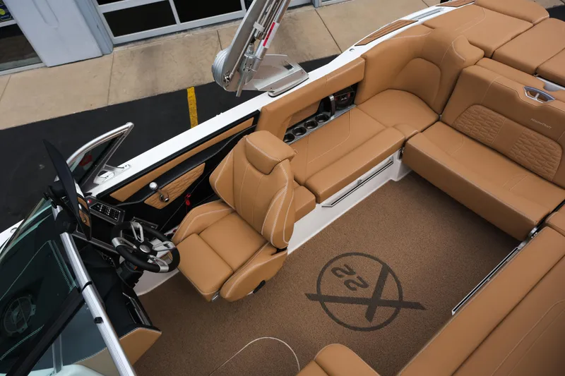Slide: The Image of 2019 MasterCraft X22 boat interior with tan leather seating and modern dashboard. - 20