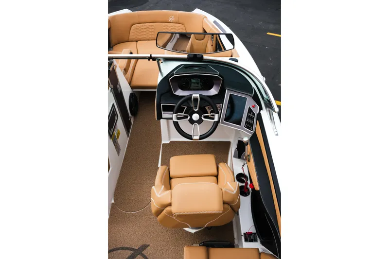 Slide: The Image of 2019 MasterCraft X22 boat interior with tan seating and modern dashboard controls. - 21