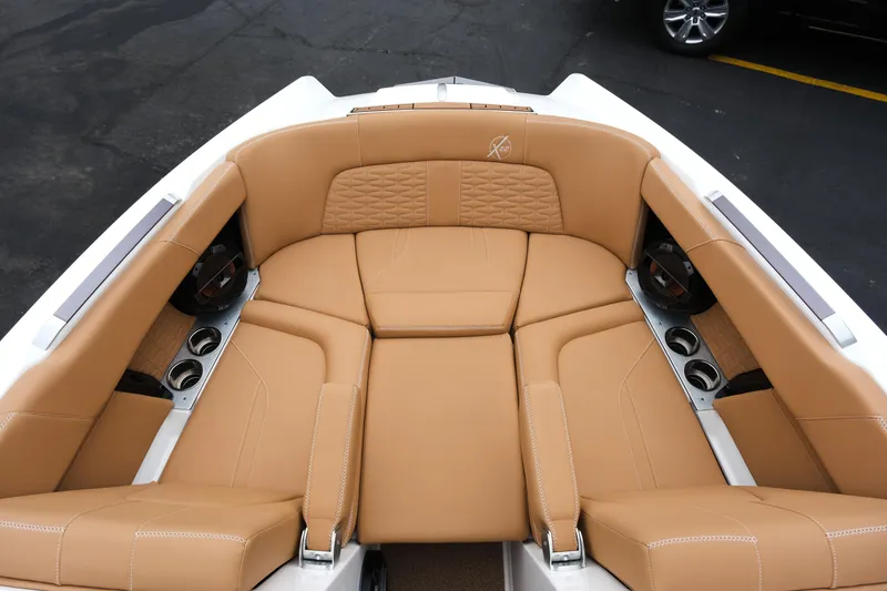 Slide: The Image of 2019 MasterCraft X22 boat interior with tan leather seating and cup holders. - 26