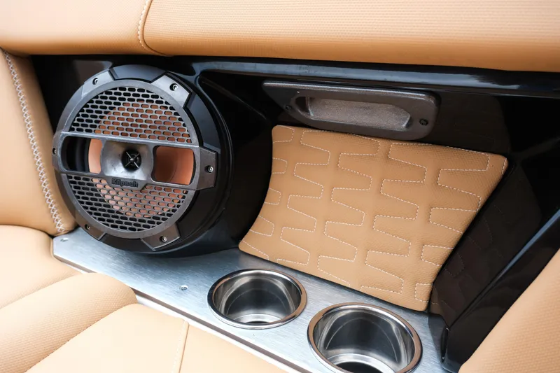 Slide: The Image of 2019 MasterCraft X22 interior with speaker, cup holders, and tan upholstery. - 27