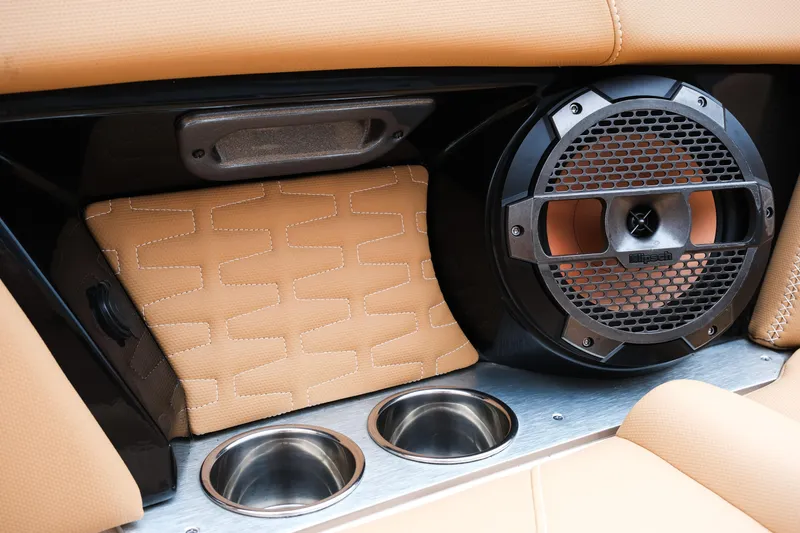 Slide: The Image of 2019 MasterCraft X22 interior with speaker, cup holders, and tan upholstery. - 28