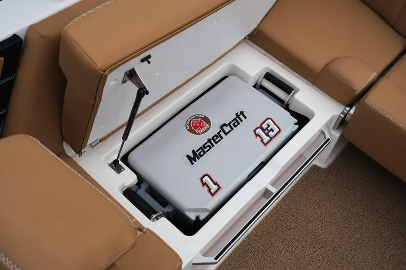 Slide: The Image of 2019 MasterCraft X22 boat storage compartment with branded cooler and tan seating. - 36