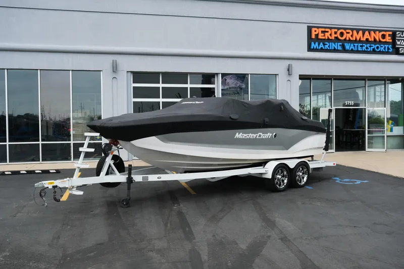 Slide: The Image of 2019 MasterCraft X22 boat on trailer, covered, outside Performance Marine Watersports store. - 40