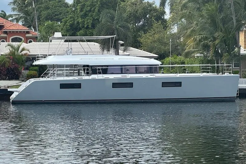 The Image of 2015 Lagoon Motor Yacht docked by lush greenery and waterfront homes. - 0