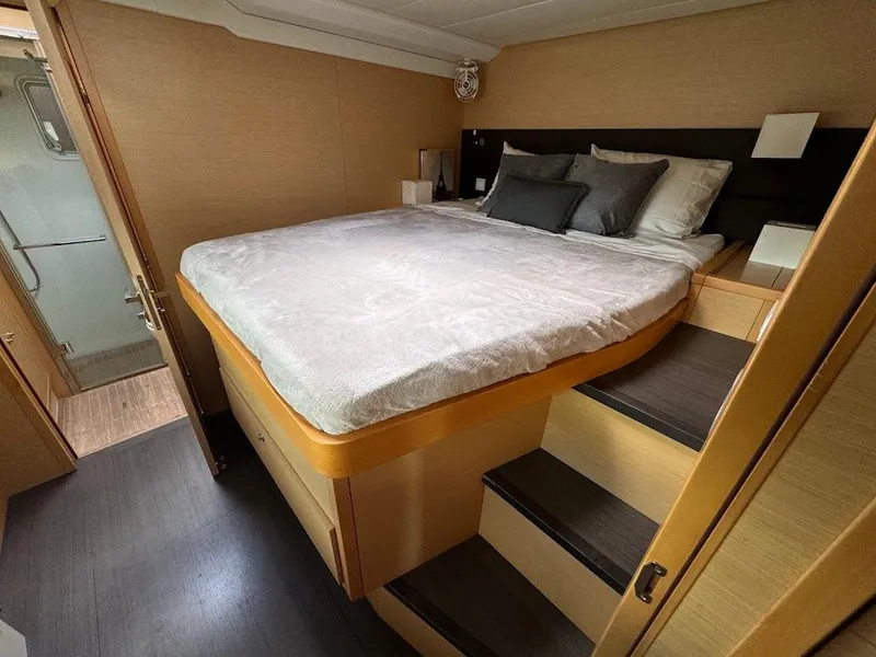 Slide: The Image of Luxurious bedroom in 2015 Lagoon Motor Yacht with elevated bed and modern decor. - 25