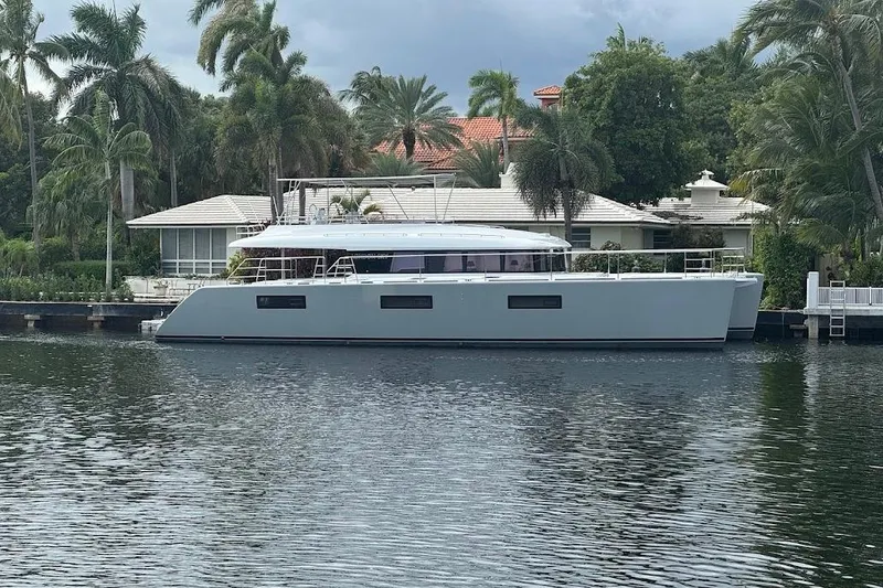 Slide: The Image of 2015 Lagoon Motor Yacht docked by a waterfront home with palm trees. - 7