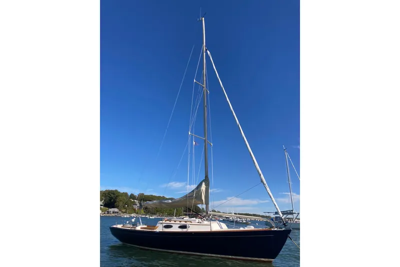The Image of 2006 Alerion Express 28 sailboat on calm water under clear blue sky. - 0