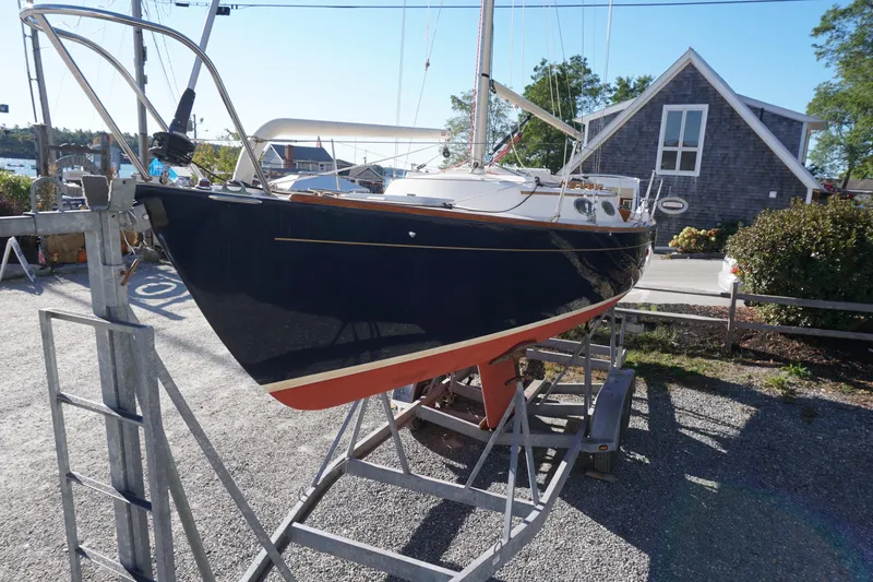 Slide: The Image of 2006 Alerion Express 28 sailboat on trailer, displayed outdoors near a building. - 15