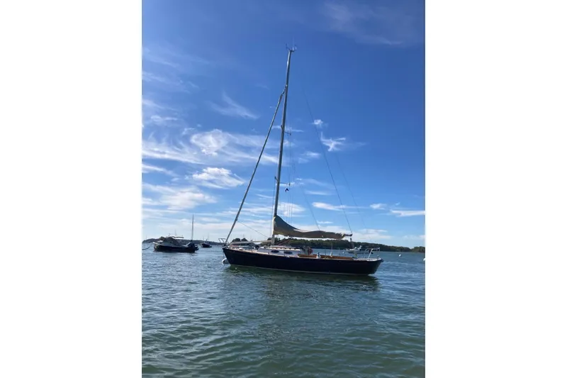 Slide: The Image of Sailboat Alerion Express 28, 2006 model, on calm water under a clear blue sky. - 2