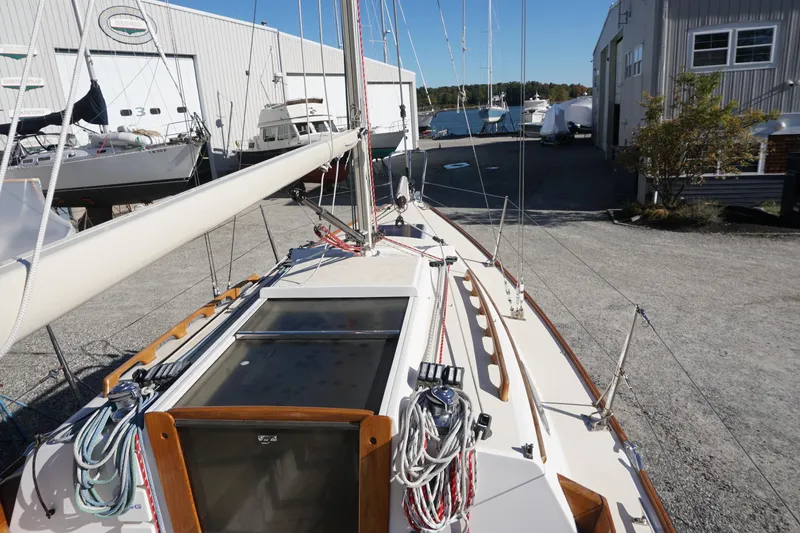 Slide: The Image of 2006 Alerion Express 28 sailboat docked at a marina, showcasing deck and rigging. - 20