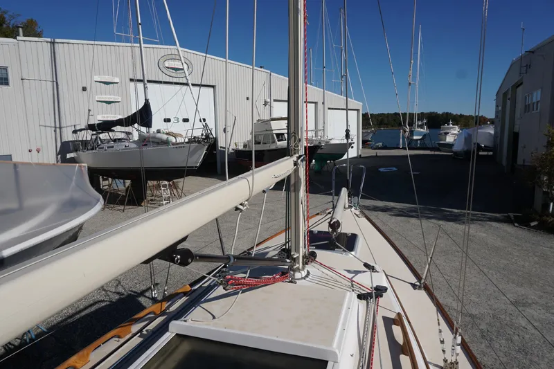 Slide: The Image of 2006 Alerion Express 28 sailboat docked near a marina with other boats. - 23