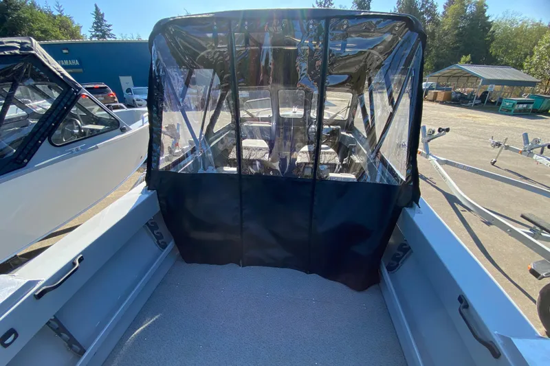 Slide: The Image of 2026 Hewescraft 180 Sportsman boat with protective canopy, parked outdoors. - 4