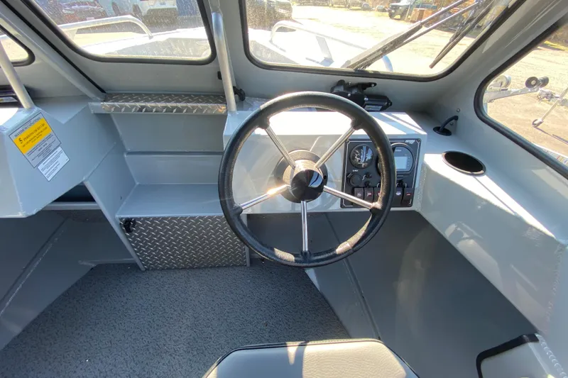 Slide: The Image of 2026 Hewescraft 180 Sportsman boat interior with steering wheel and dashboard controls. - 8