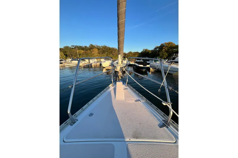 Slide: The Image of Bow view of a 1996 Catalina 400 sailboat docked in a serene marina. - 19