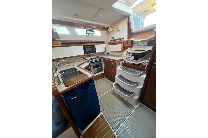 Slide: The Image of Interior of 1996 Catalina 400 sailboat kitchen with modern amenities and wooden accents. - 32