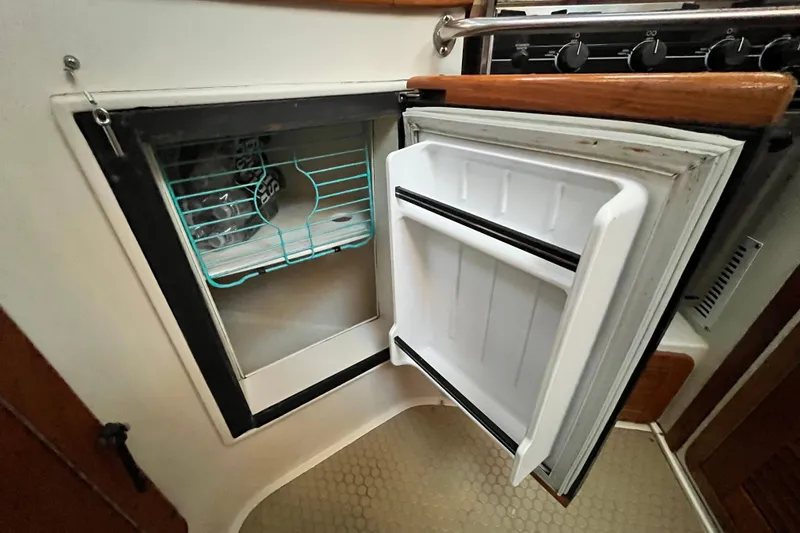 Slide: The Image of Open refrigerator in 1996 Catalina 400 yacht kitchen, showing interior shelves. - 37
