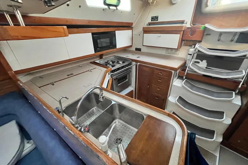 Slide: The Image of Interior of a 1996 Catalina 400 sailboat kitchen with sink, stove, and storage. - 41