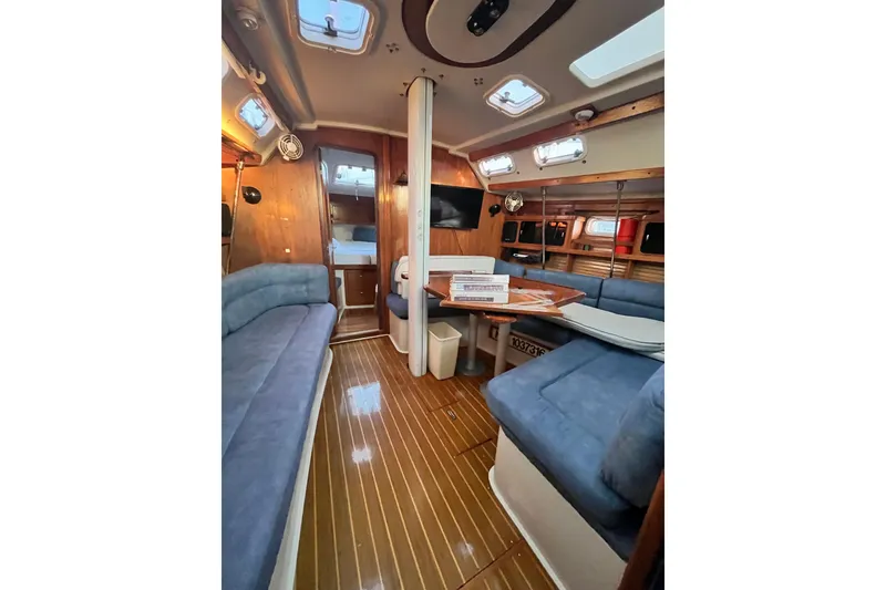 Slide: The Image of Interior of a 1996 Catalina 400 sailboat with blue seating and wooden finishes. - 44