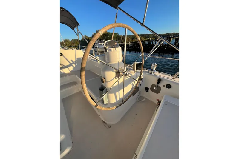 Slide: The Image of Steering wheel of a 1996 Catalina 400 sailboat, docked by the water. - 5